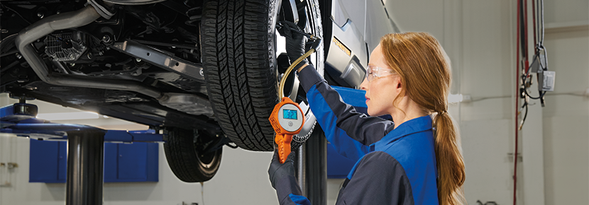 A Subaru technician checking tire pressure. | i.g. Burton Subaru of Glen Burnie in Glen Burnie MD