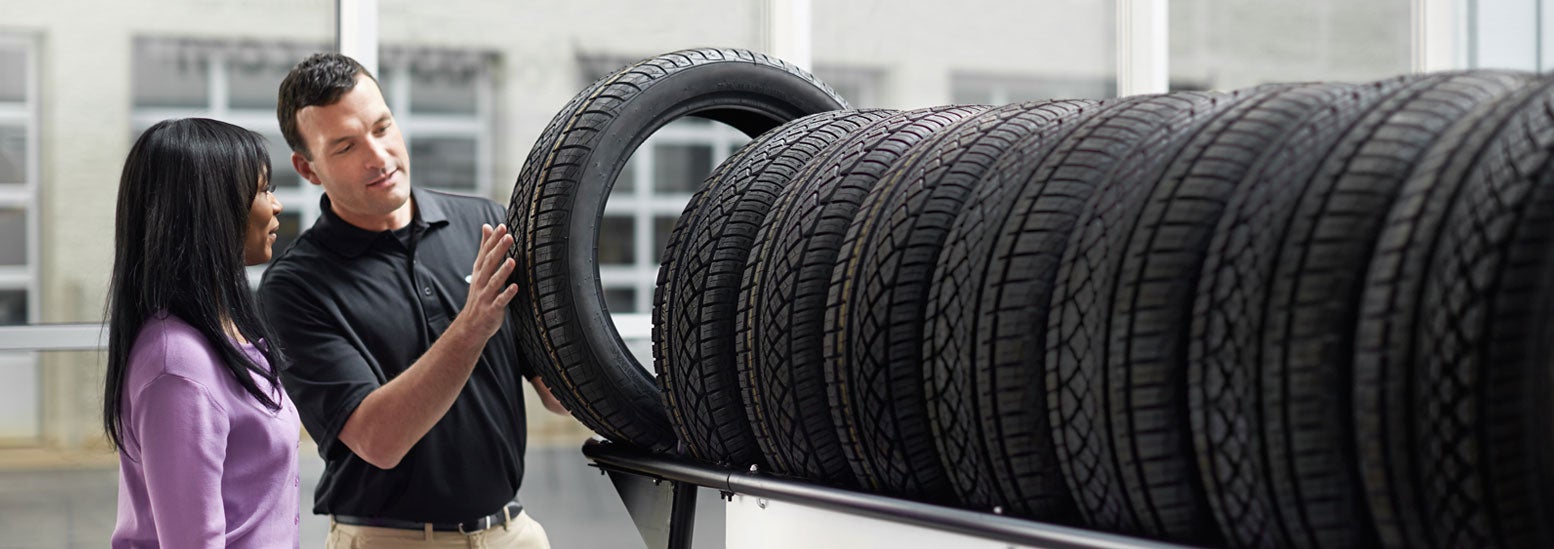 Subaru service representative showing customer a tire. | i.g. Burton Subaru of Glen Burnie in Glen Burnie MD