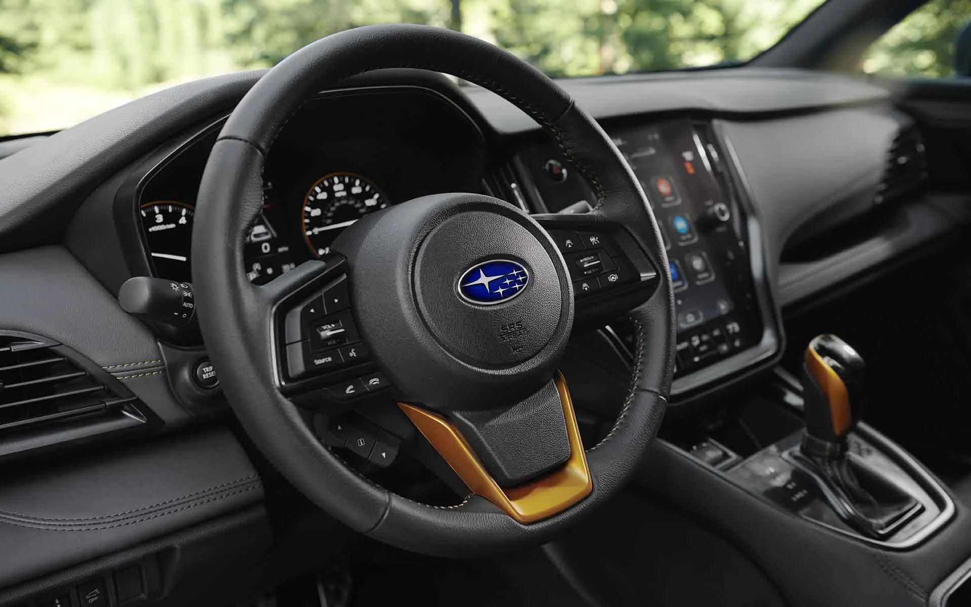 Driver's view of a car interior with a black steering wheel, digital dashboard, and infotainment screen.