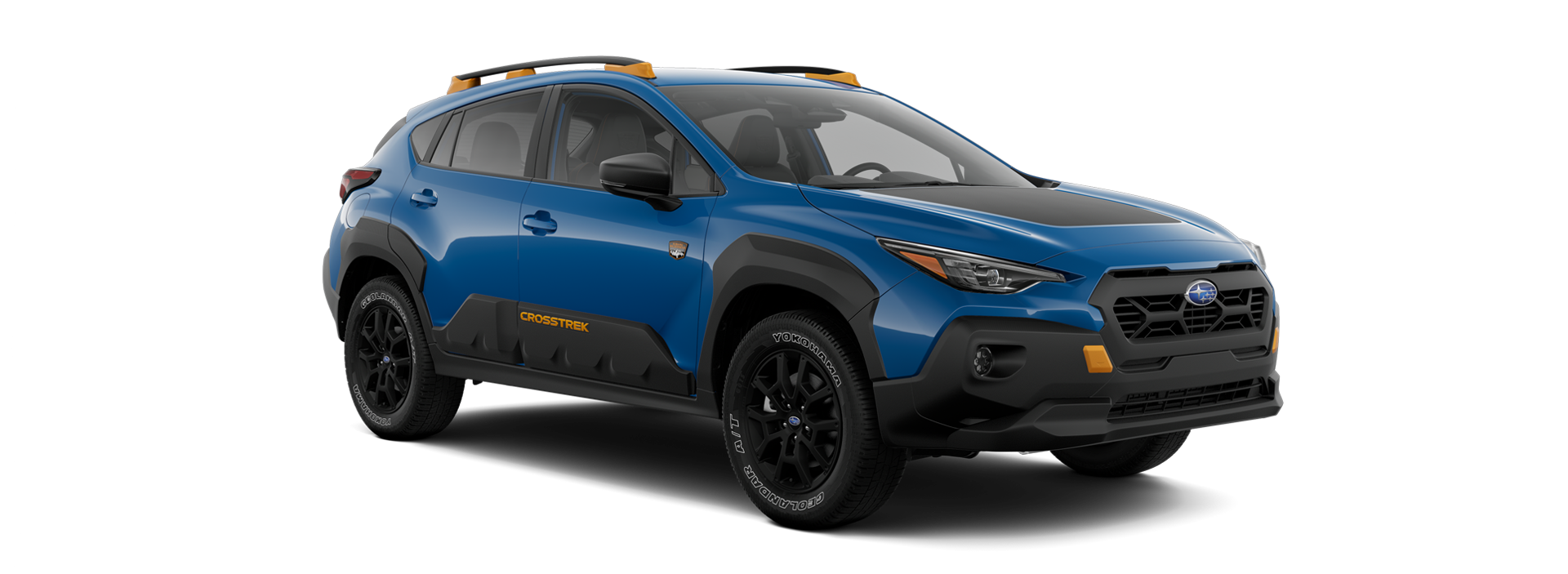 A blue Subaru Crosstrek Wilderness Edition, with a dark hood stripe and orange accents, angled right on a black background.