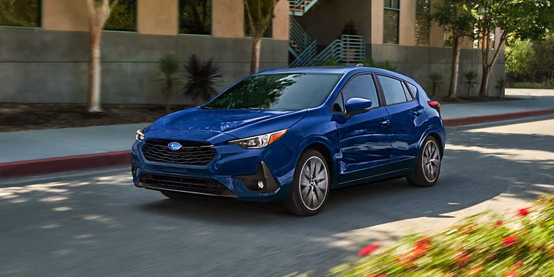 Blue Compact Hatchback Driving Through a City Street