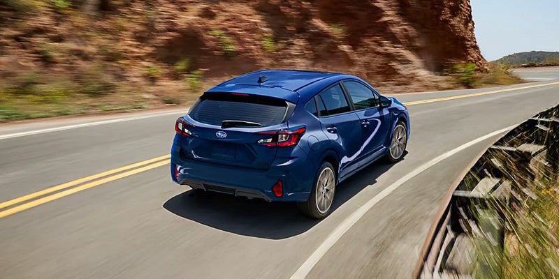 Rear View of a Blue Hatchback on an Open Road