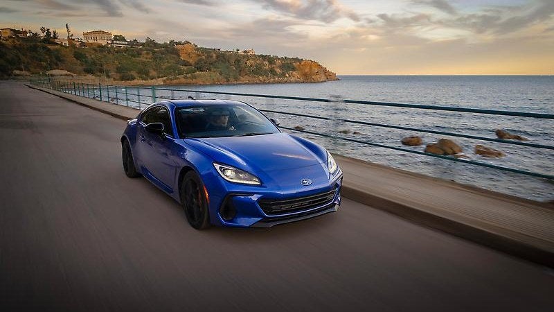 2025 Subaru BRZ in blue, front three-quarter on a coastal road
