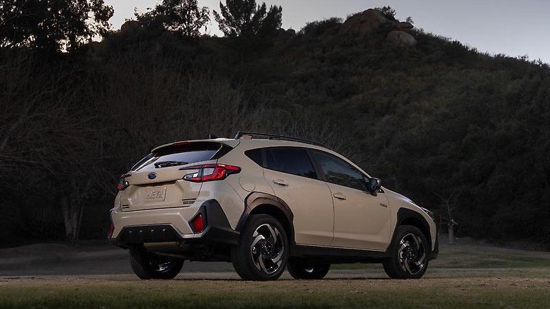 Subaru Crosstrek Hybrid in tan, three-quarter view in a forest