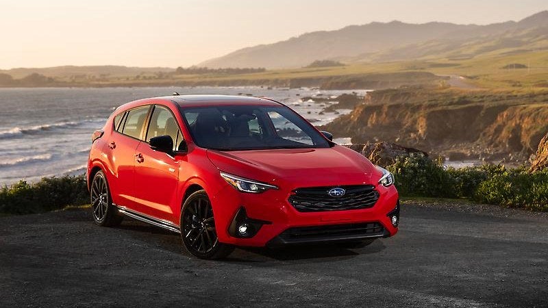 2026 Subaru Impreza in red, front three-quarter on a coastal overlook