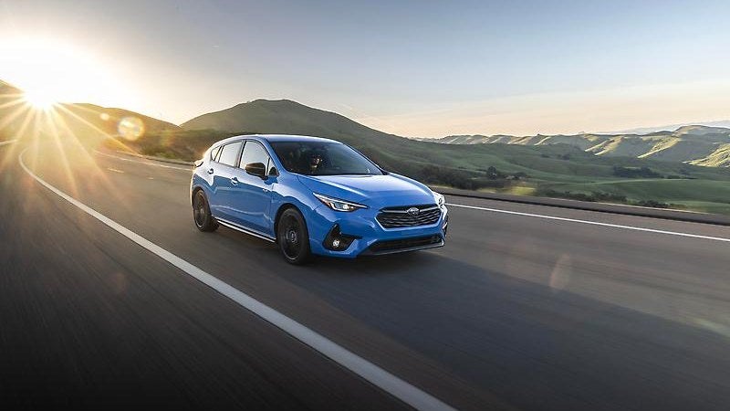 2025 Subaru Impreza in blue, three-quarter view on a rural road
