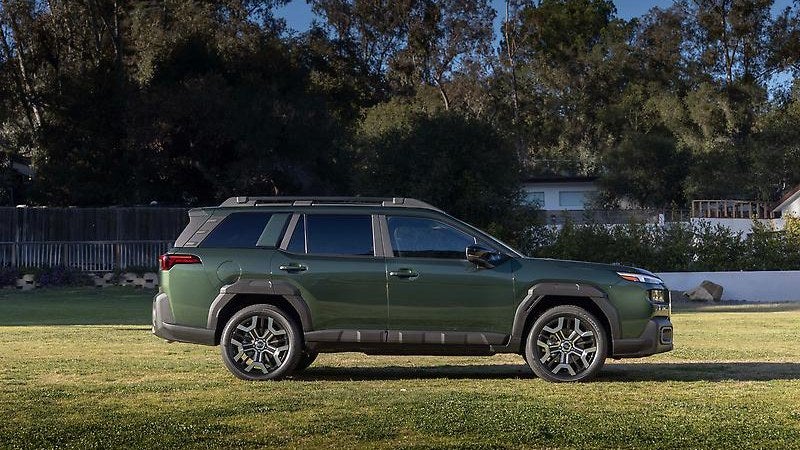 2025 Subaru Outback, green, three-quarter view in a grassy field