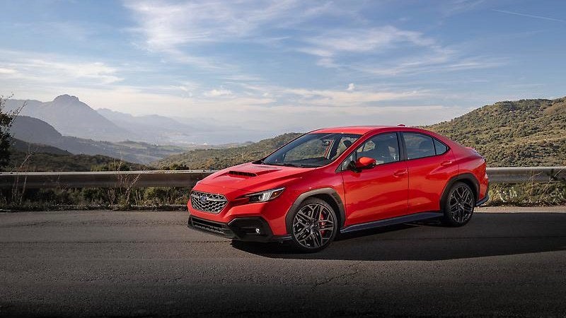 2024 Subaru WRX in red, front three-quarter on a mountain road