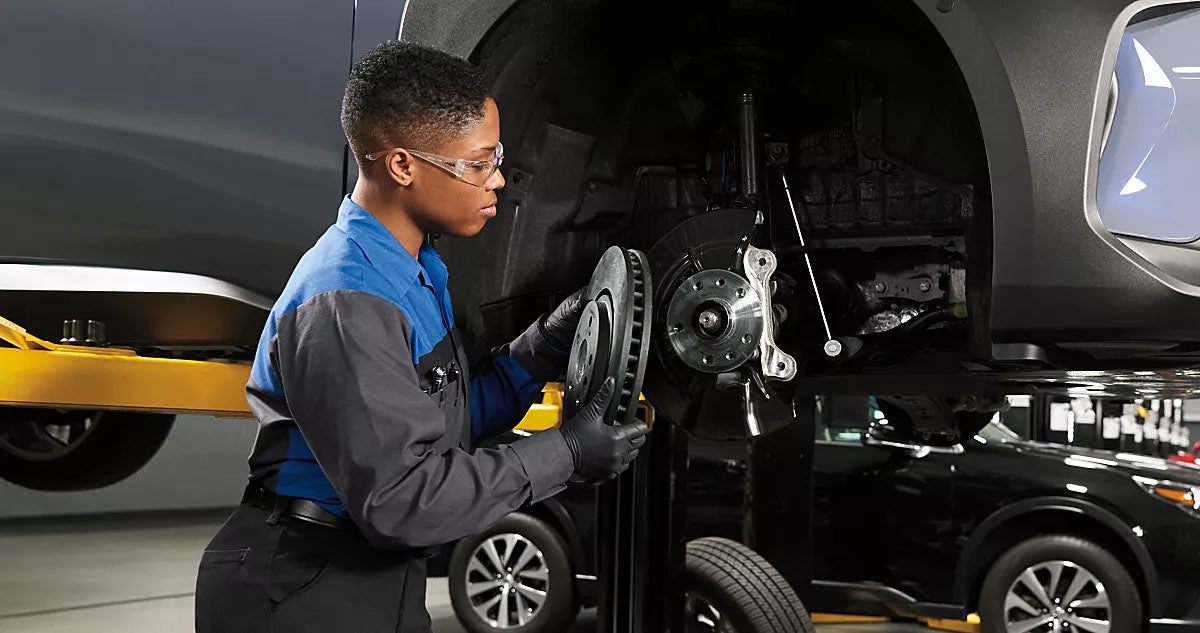 A technician putting a brake rotor on a vehicle